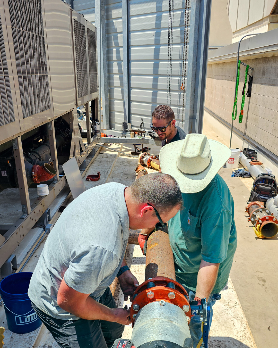 Zion Engineering team working together on rooftop mechanical equipment.