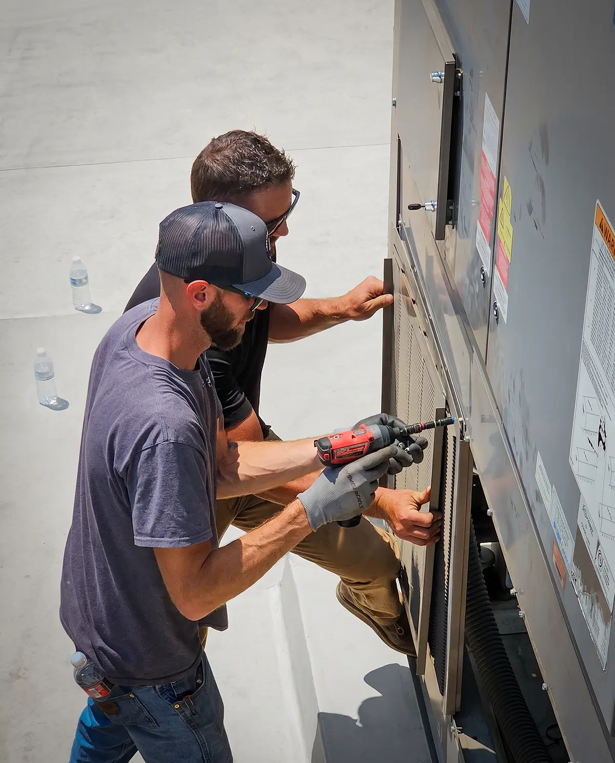 Zion Engineering technician reviewing commercial HVAC equipment, access, and site conditions before installation