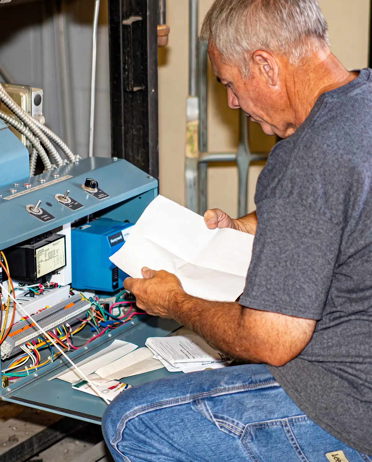 Zion Engineering technician inspecting covered commercial HVAC equipment during a scheduled preventative maintenance visit